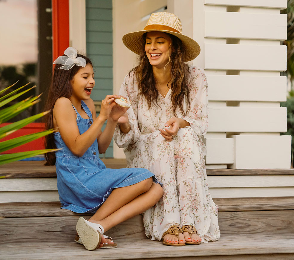Mother and daughter laughing together on a cottage porch