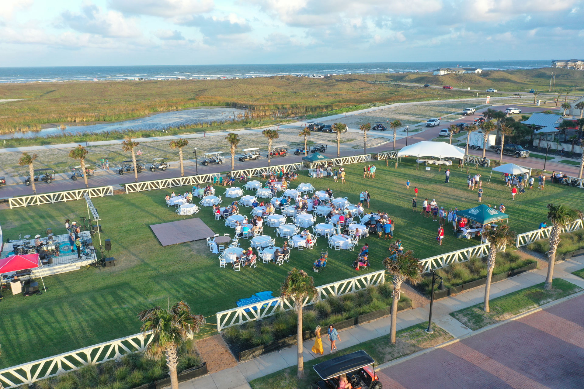 Aerial view of an outdoor community event on the lawn at Palmilla Beach