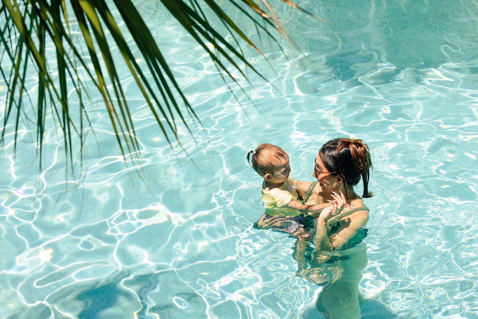 A parent and child swimming underwater in the Palmilla Beach resort pool