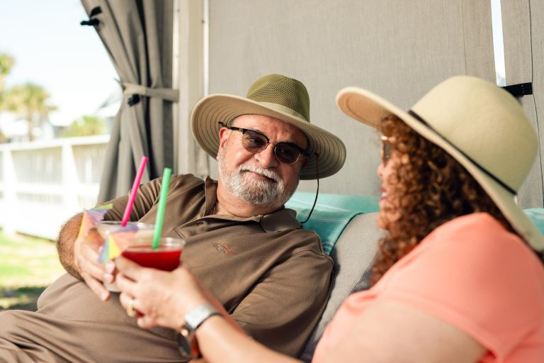 Couple relaxing with drinks in a private cabana at the Oasis Pool