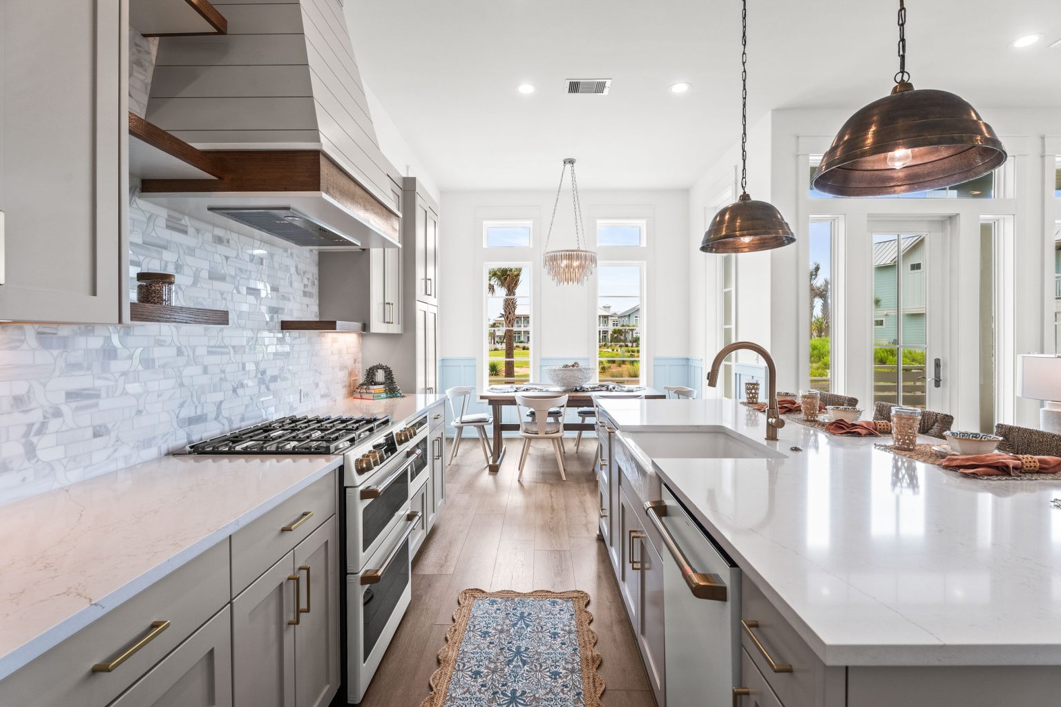 Galley-style kitchen with gas range, island and copper pendants at 120 Lotus Lane
