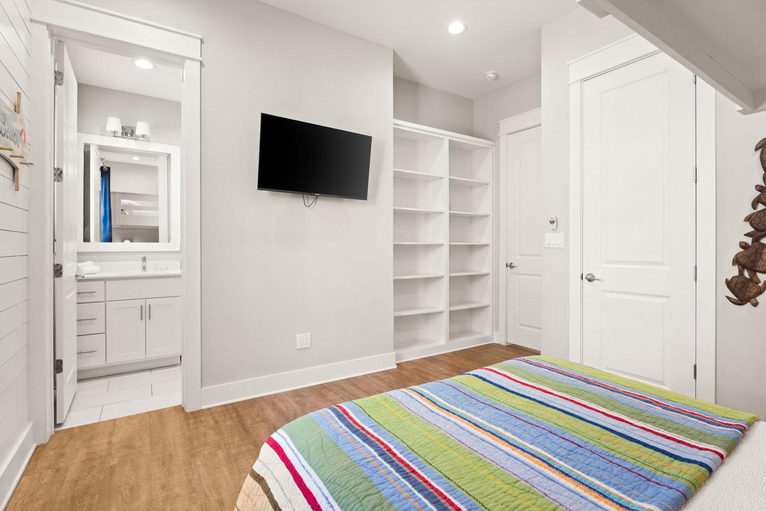 Bedroom with a wall-mounted TV and open shelving at 200 Sunset Avenue