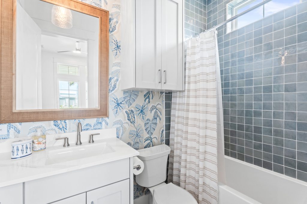 Bathroom with leaf wallpaper and blue tile tub-shower at 205 Horse Tail Lane