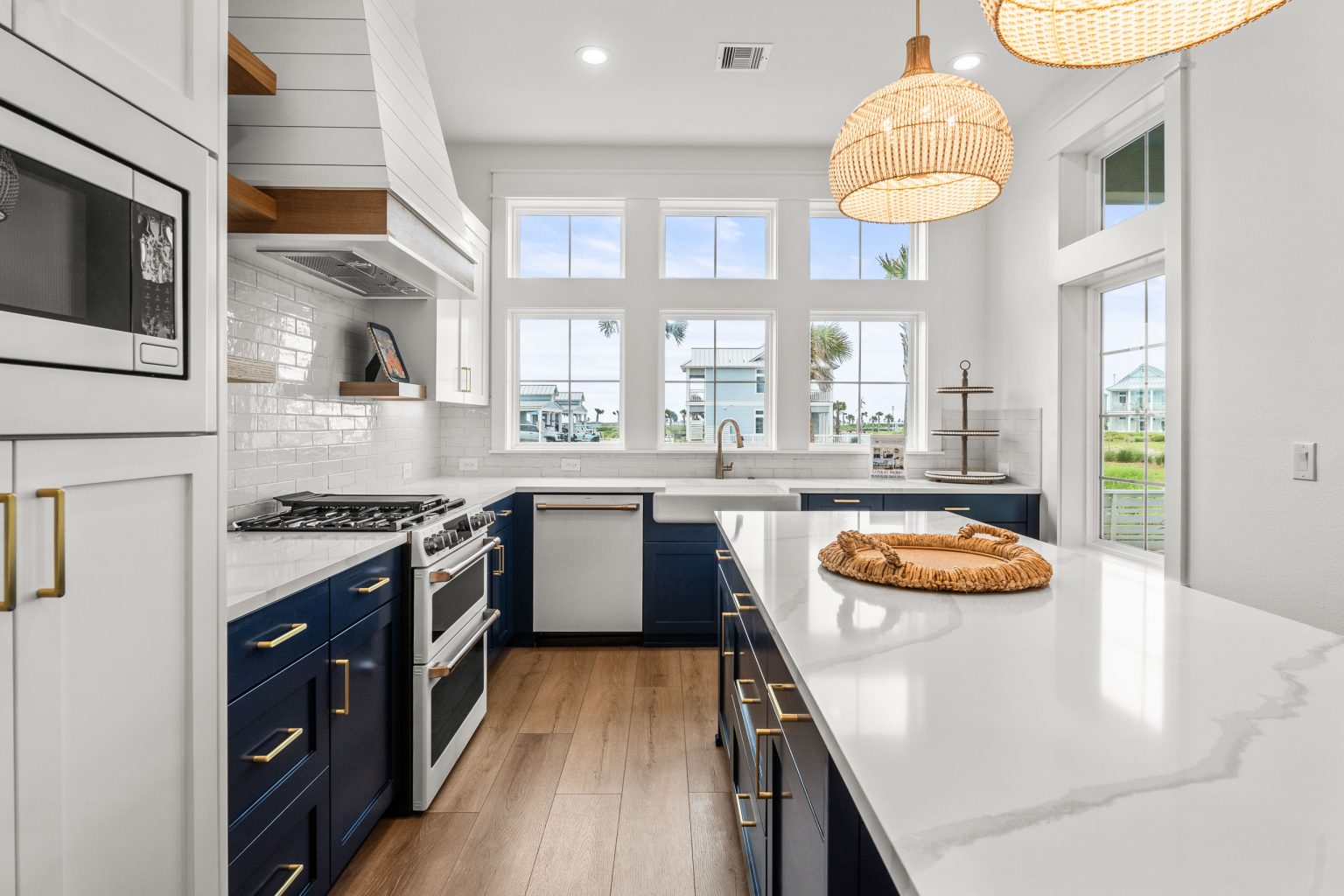 Kitchen with navy cabinets, marble island and rattan pendants at 209 Horse Tail Lane