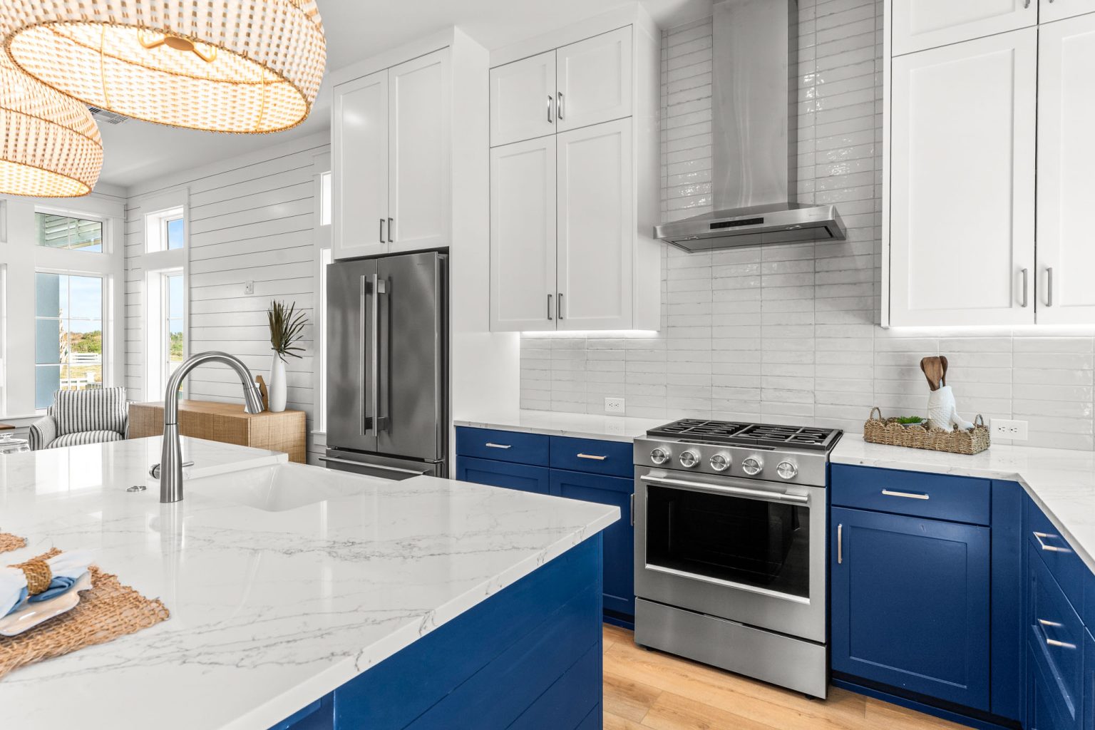 Kitchen with navy cabinets, gas range and marble island at 101 Sea Whip Lane
