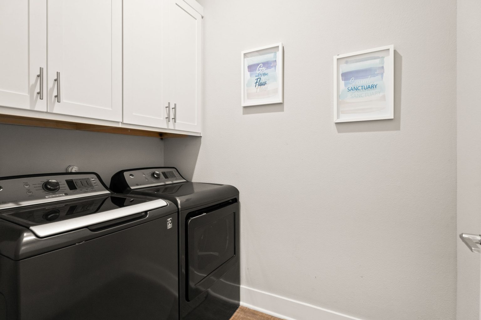 Laundry room with washer, dryer and upper cabinets at 200 Sunset Avenue