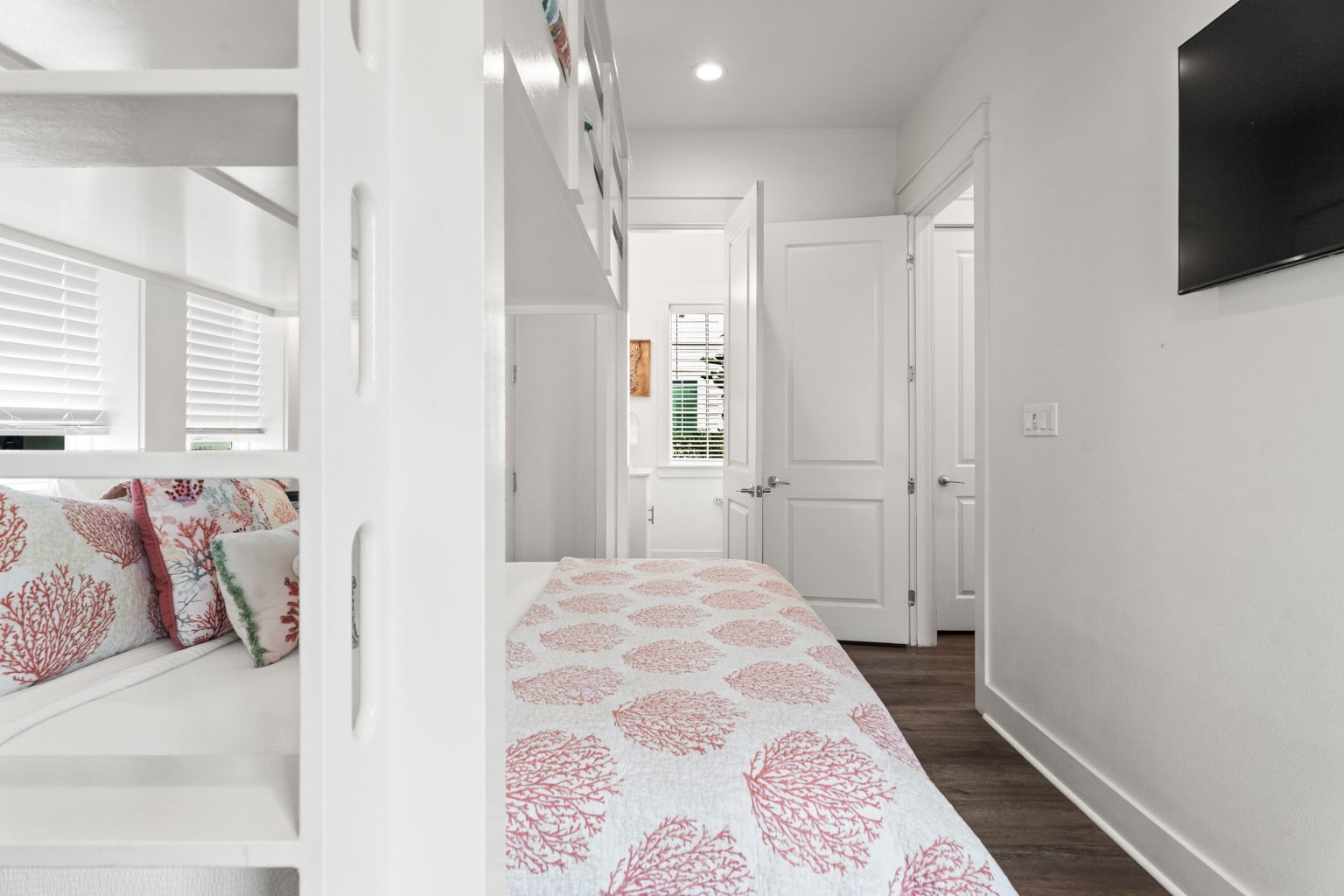 Bunk room with coral bedding and wall-mounted TV at 214 Sunset Avenue #4