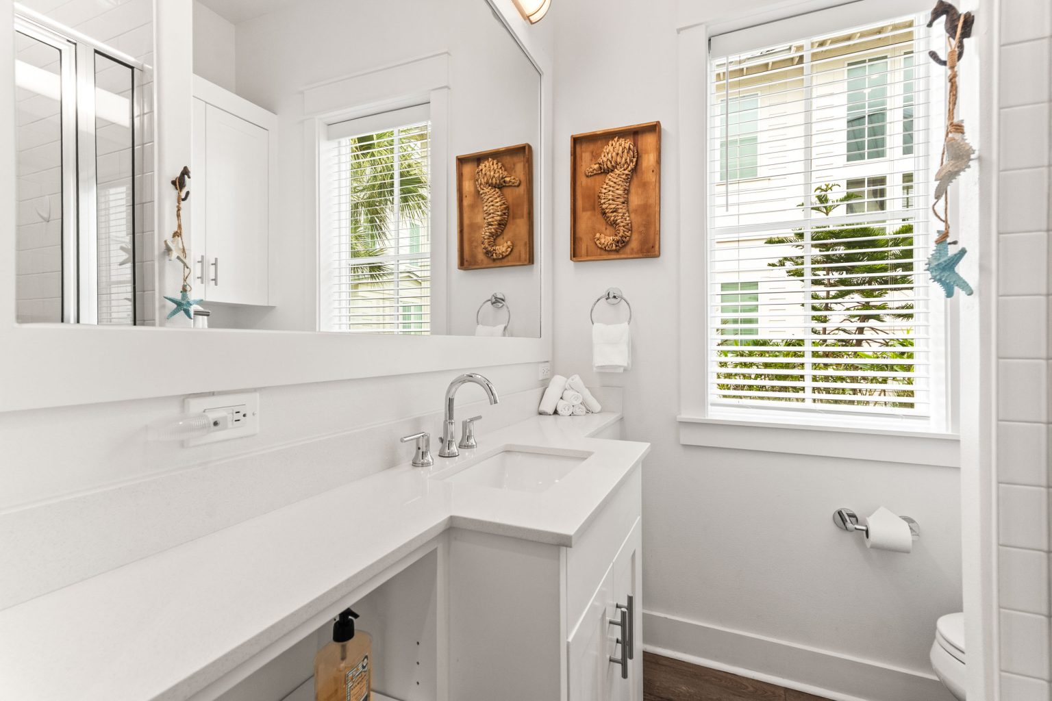 Bathroom with a long white vanity and seahorse art at 214 Sunset Avenue #5