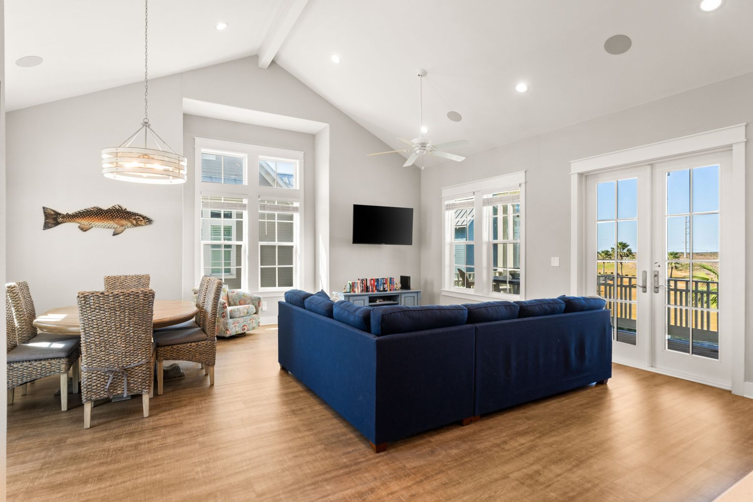 Open living and dining area with a blue sectional and French doors at 200 Sunset Avenue