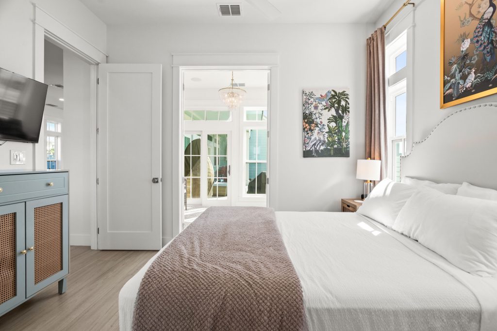 Bedroom with a white bed and French doors beyond at 724 Sunset Avenue