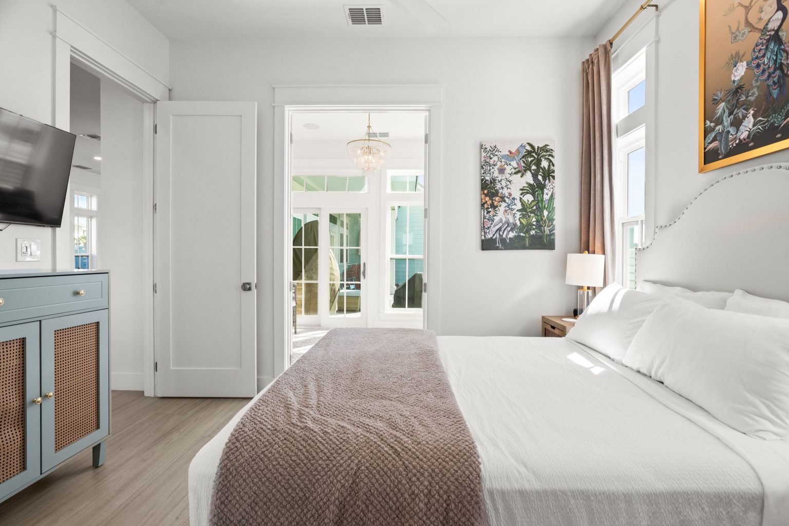 Bedroom with a white bed and French doors beyond at 724 Sunset Avenue