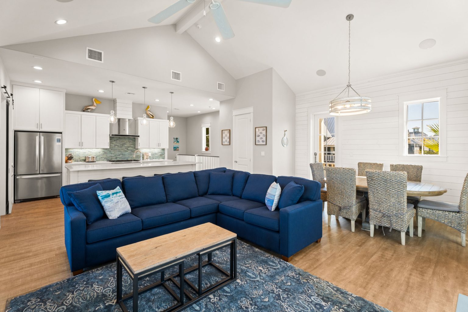 Living room with a blue sectional open to the kitchen and dining area at 200 Sunset Avenue