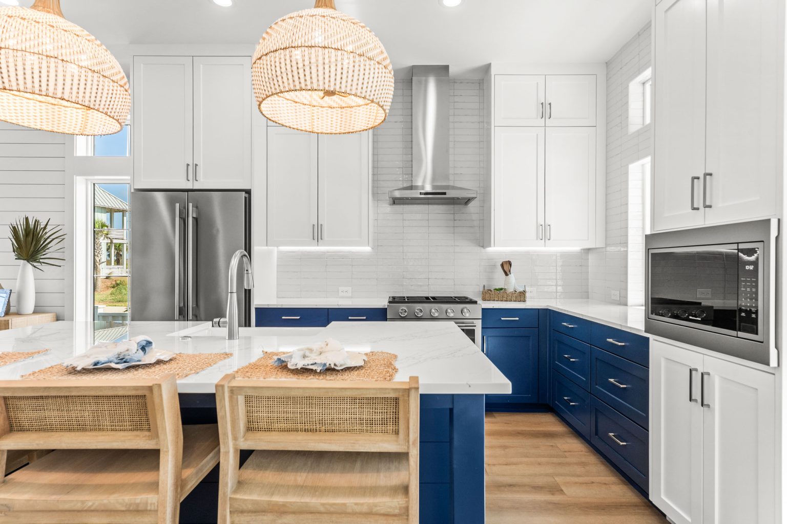 Kitchen island with seating and navy lower cabinets at 101 Sea Whip Lane