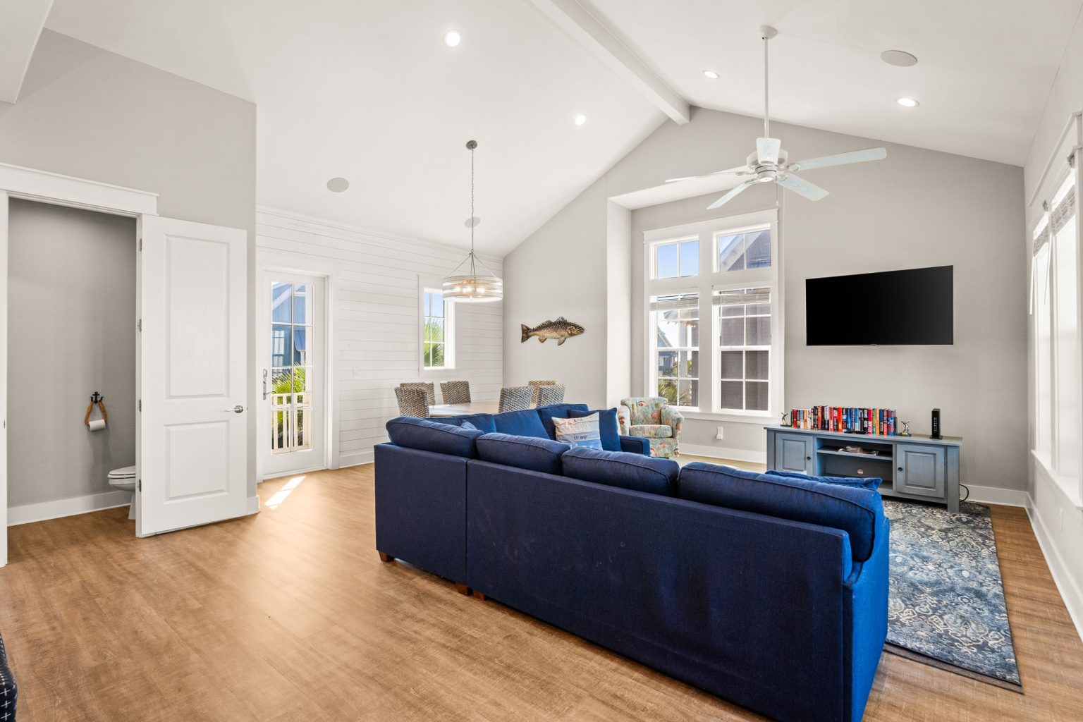 Vaulted living room with a blue sectional and wall-mounted TV at 200 Sunset Avenue
