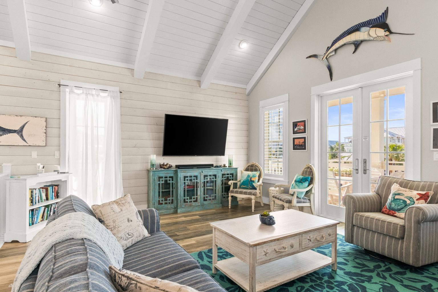 Living room with a marlin mount, TV and French doors at 152 Sea Rocket Lane