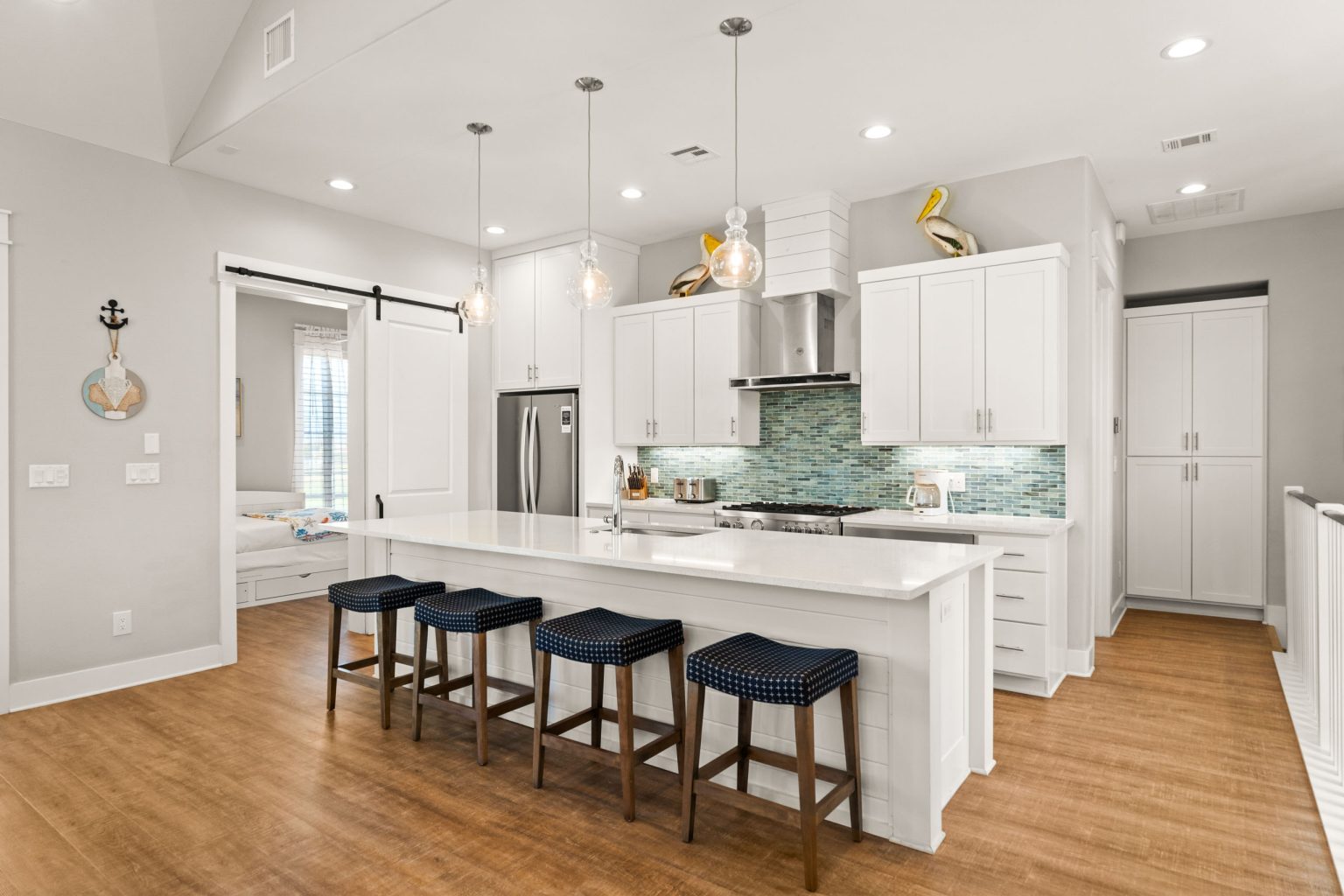 Kitchen with white cabinets, blue barstools and a large island at 200 Sunset Avenue