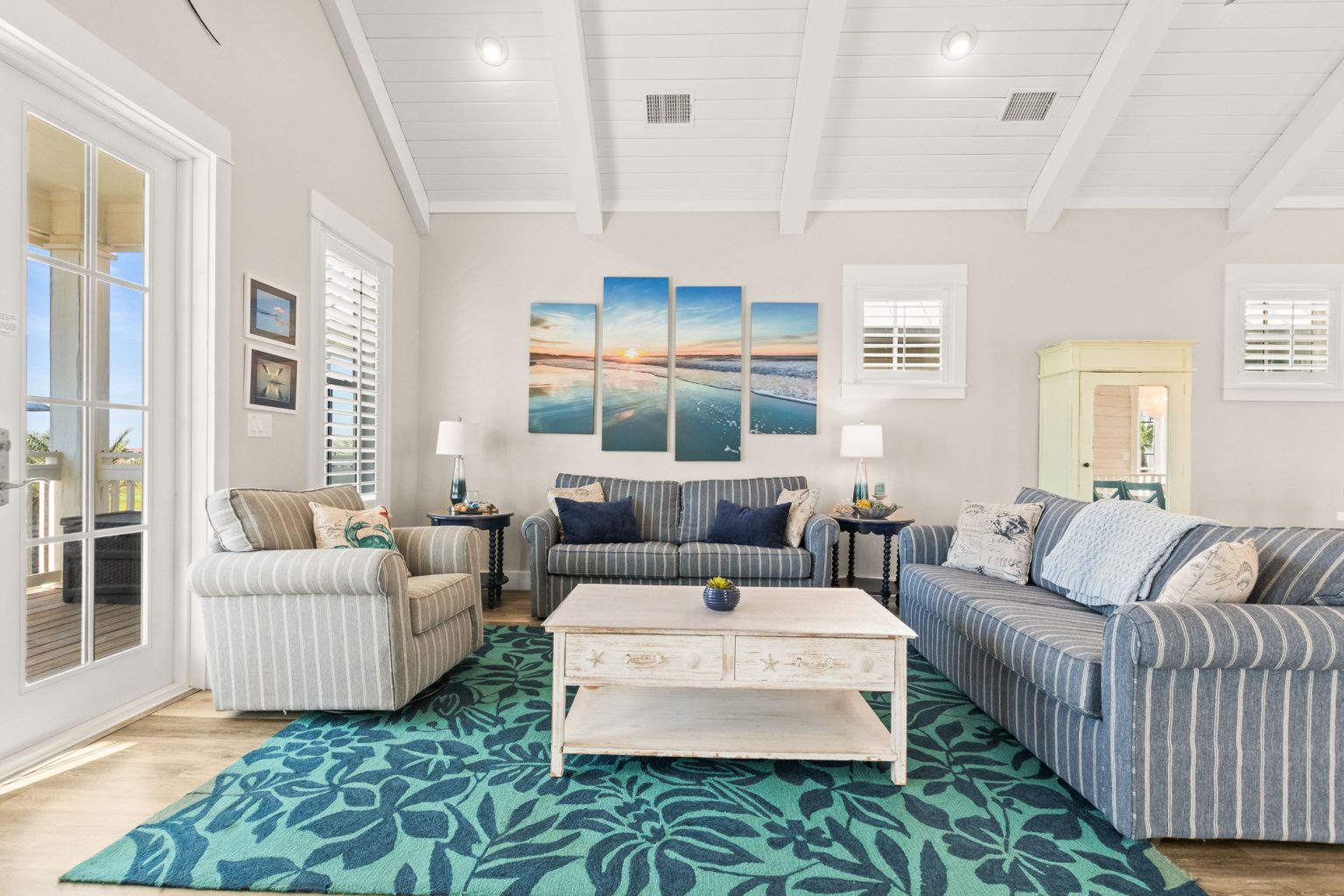 Living room with striped sofas and a teal area rug at 152 Sea Rocket Lane