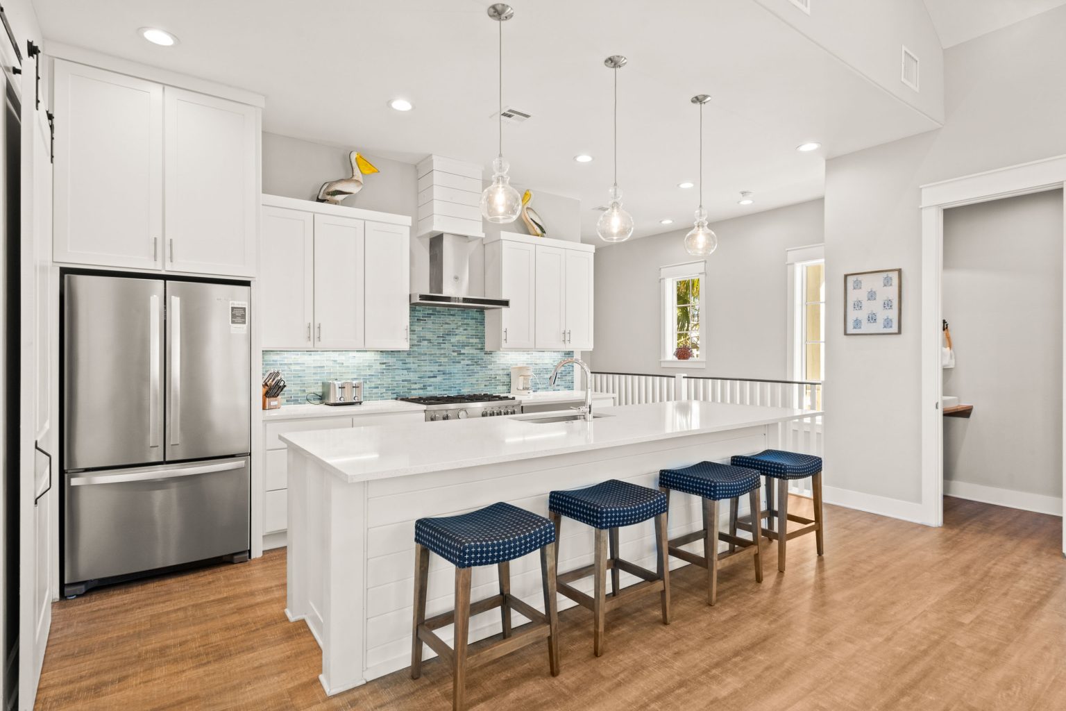 Kitchen with stainless refrigerator, pendant lights and island seating at 200 Sunset Avenue