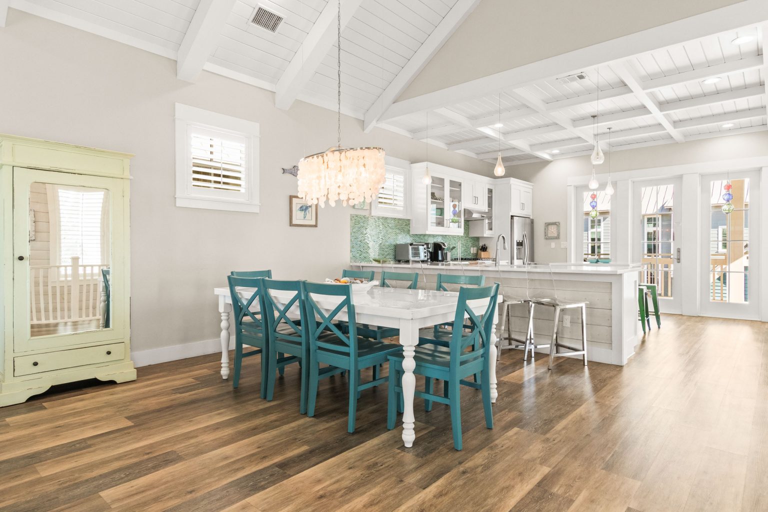 Dining area with teal chairs, open to the kitchen at 152 Sea Rocket Lane