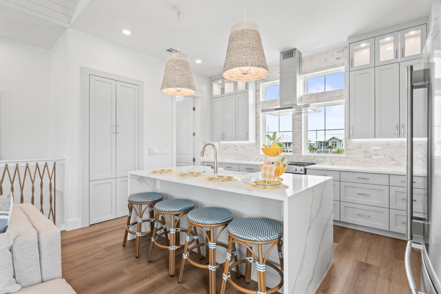 Kitchen with a waterfall island, rattan pendants and striped stools at 205 Horse Tail Lane