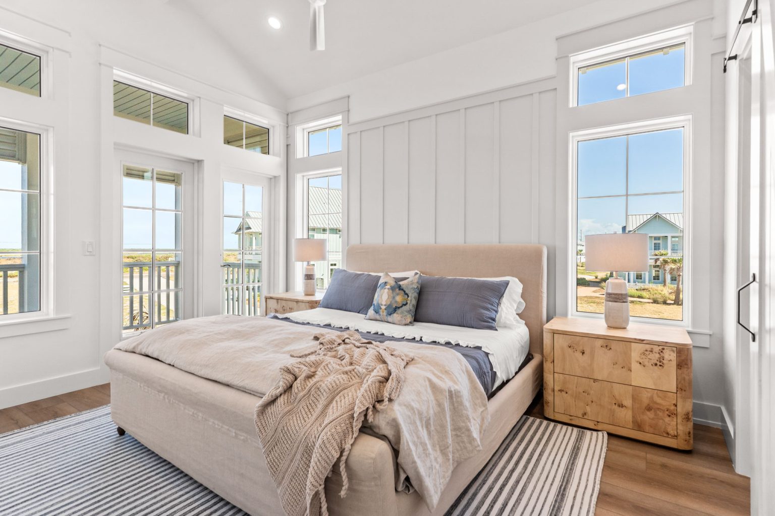 Primary bedroom with a vaulted ceiling and porch doors at 101 Sea Whip Lane