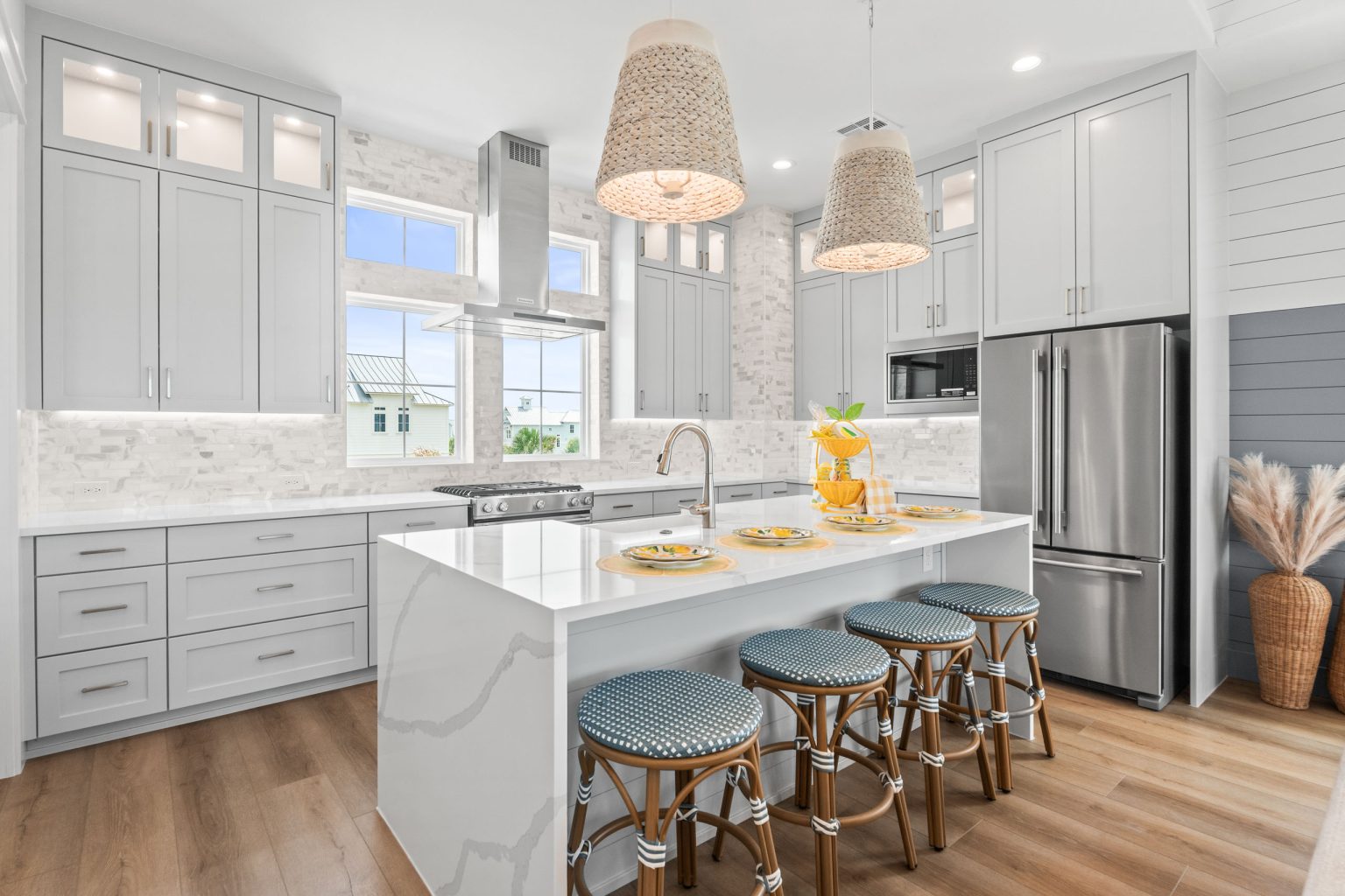 Kitchen with gray cabinets, island seating and stainless refrigerator at 205 Horse Tail Lane