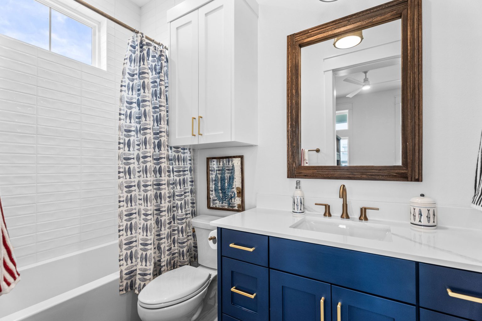 Bathroom with a navy vanity and tub-shower at 209 Horse Tail Lane