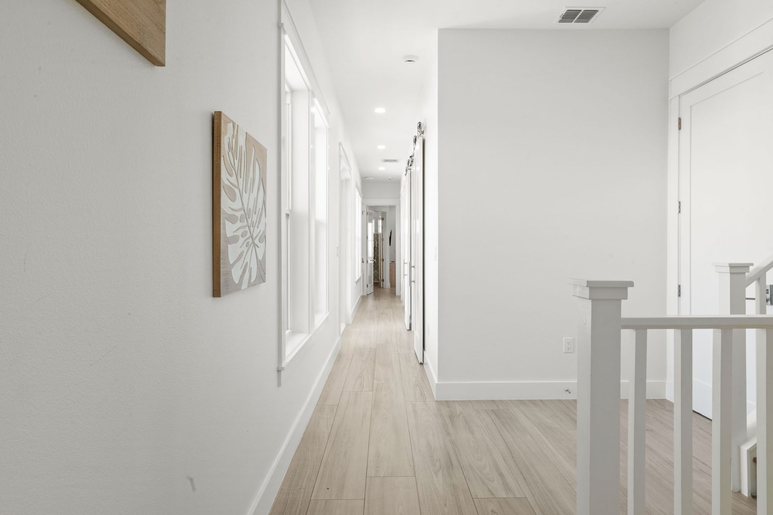 Upstairs hallway with a white railing at 724 Sunset Avenue