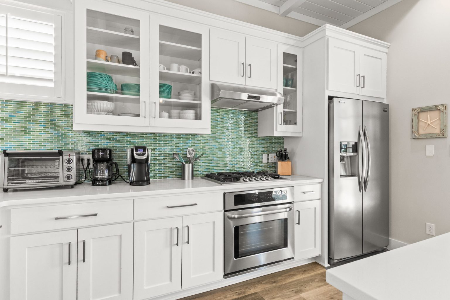 Kitchen with green glass tile backsplash and stainless appliances at 152 Sea Rocket Lane