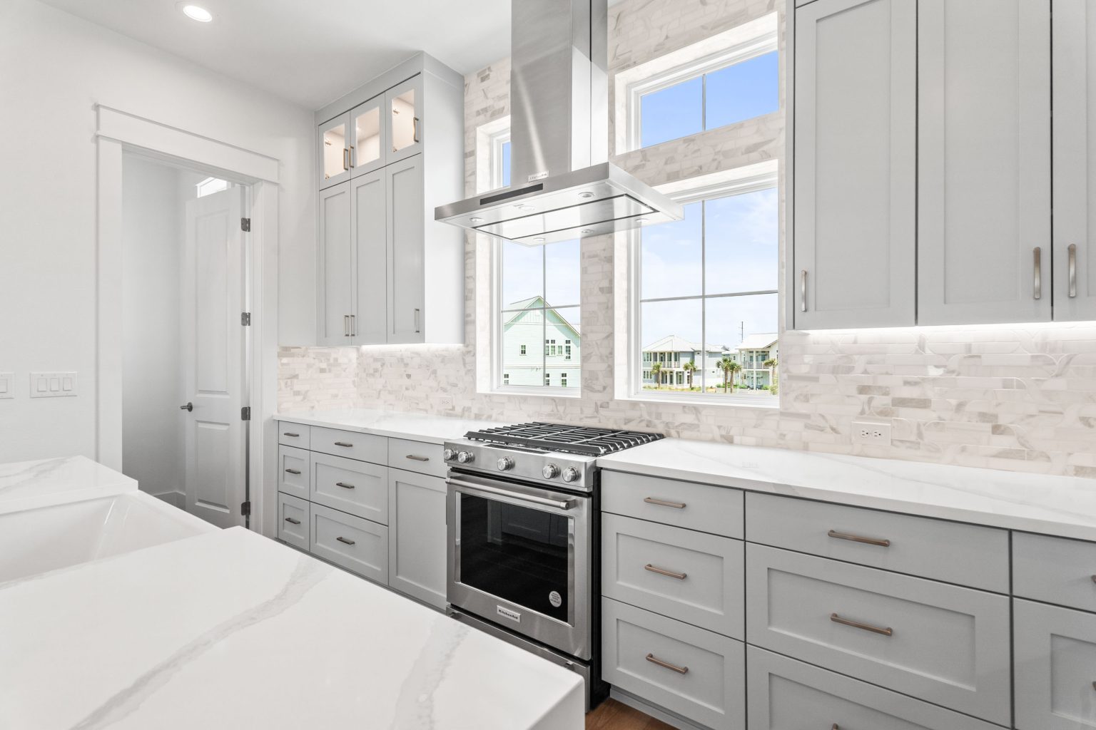Kitchen with gas range and marble tile backsplash at 205 Horse Tail Lane