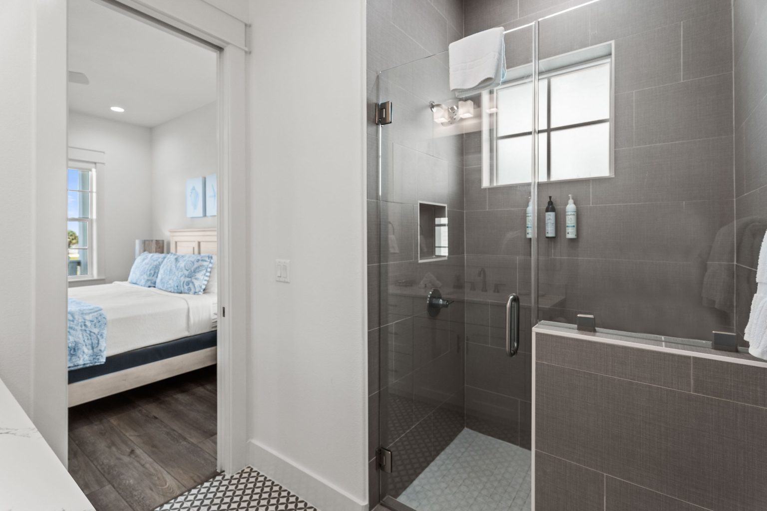 Bathroom with a gray-tiled walk-in shower beside a bedroom at 250 Sunrise Avenue