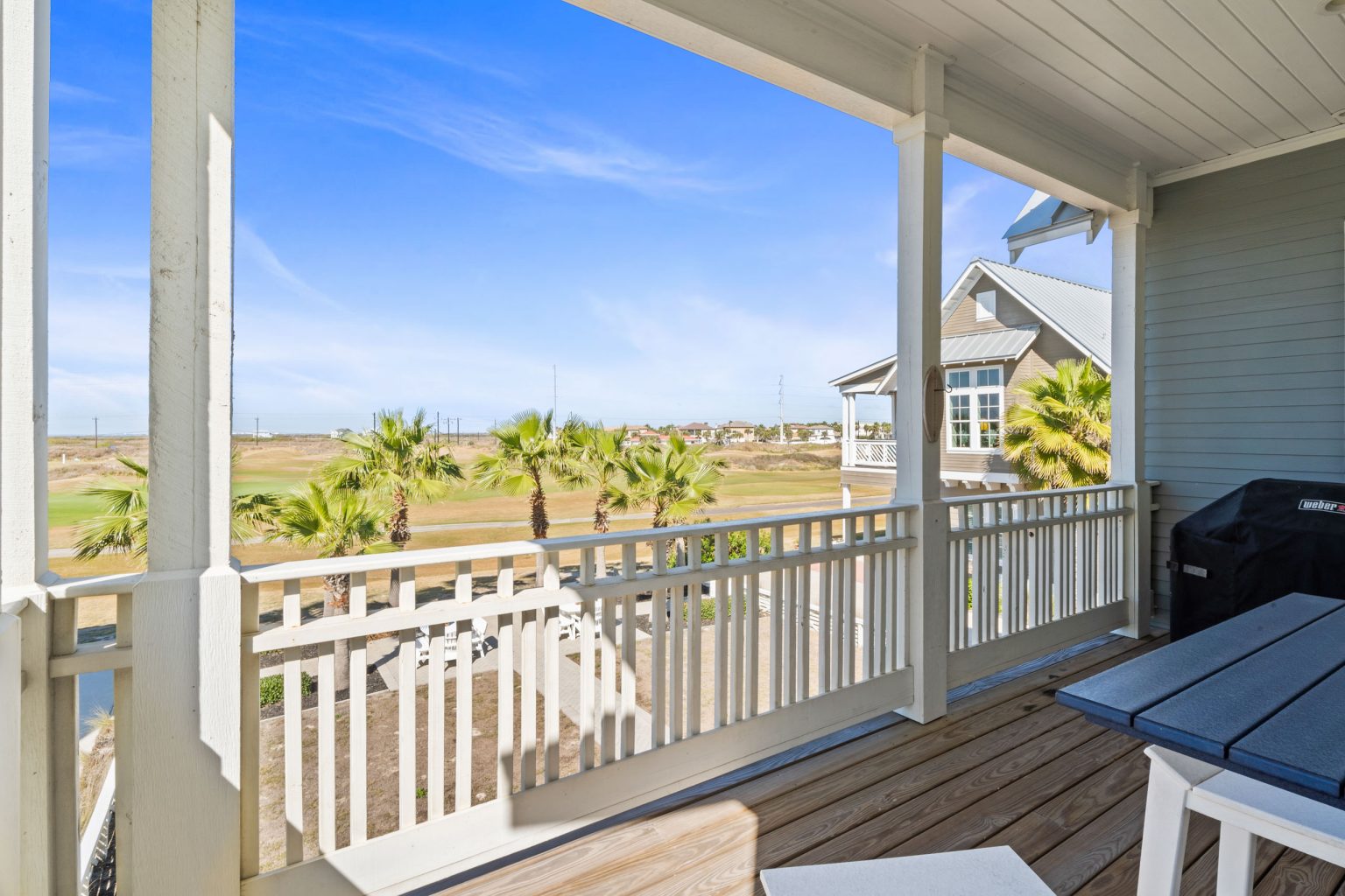 Upper porch with views over palms and marsh at 200 Sunset Avenue