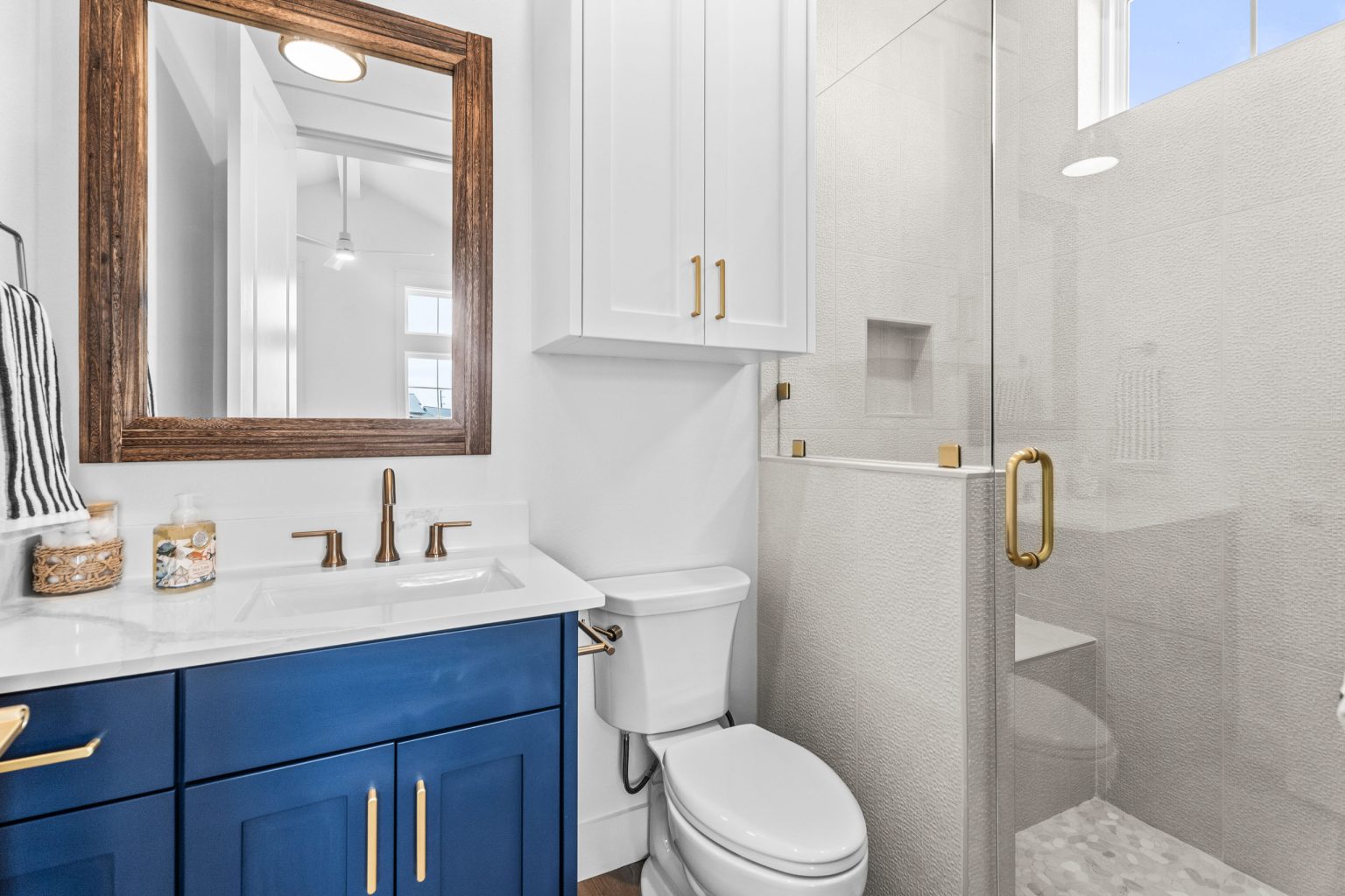 Bathroom with a navy vanity and glass shower at 209 Horse Tail Lane