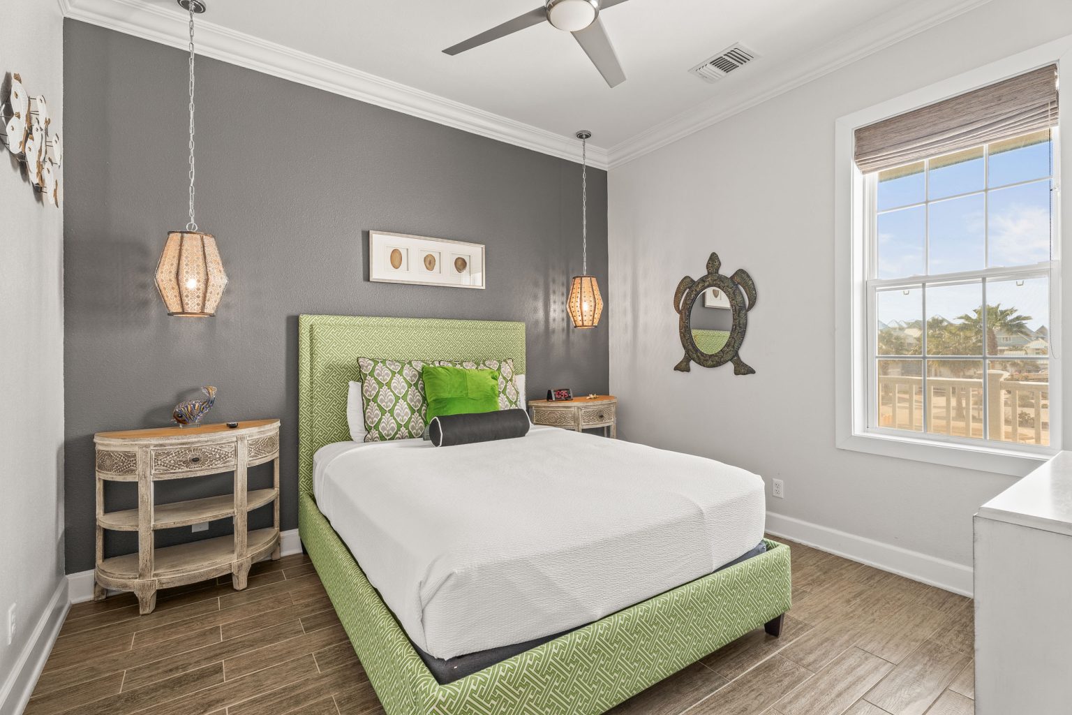 Bedroom with a green upholstered bed and pendant lights at 137 Palmilla Circle #204