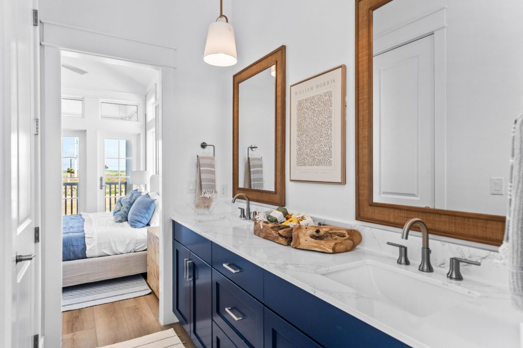 Bathroom with a navy vanity and wood-framed mirrors at 101 Sea Whip Lane