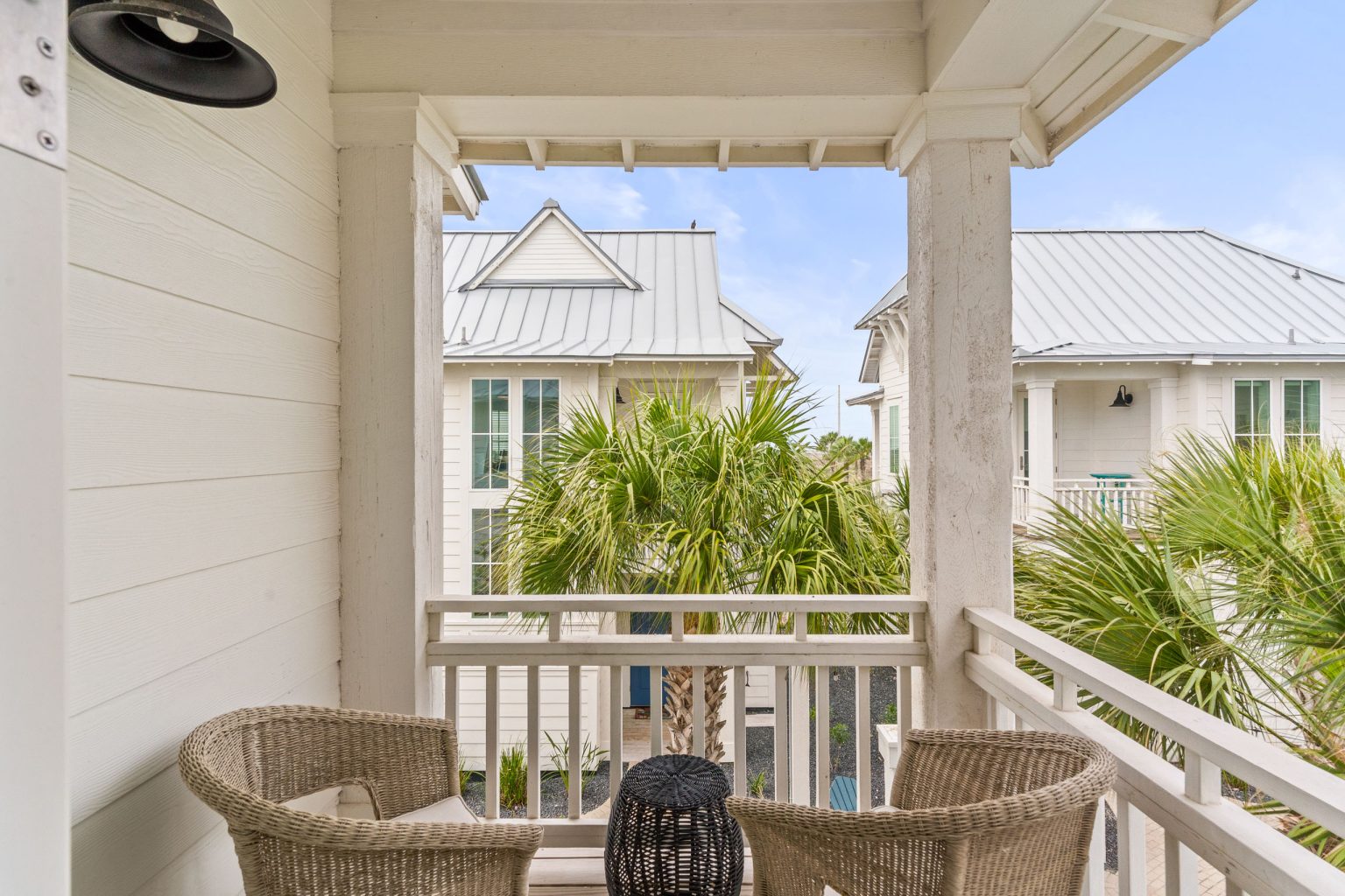 Upper balcony with wicker chairs and palm views at 214 Sunset Avenue #4