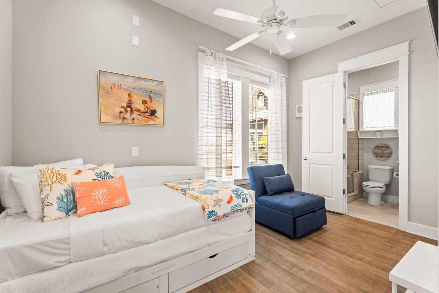 Bedroom with a daybed, blue armchair and en suite bath at 200 Sunset Avenue