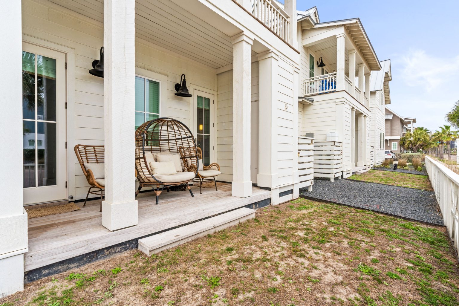 Covered porch with egg chair and side yard at 214 Sunset Avenue #5