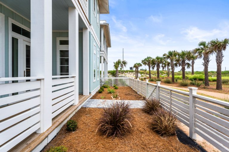 Side porch and landscaped yard with palms at 120 Lotus Lane