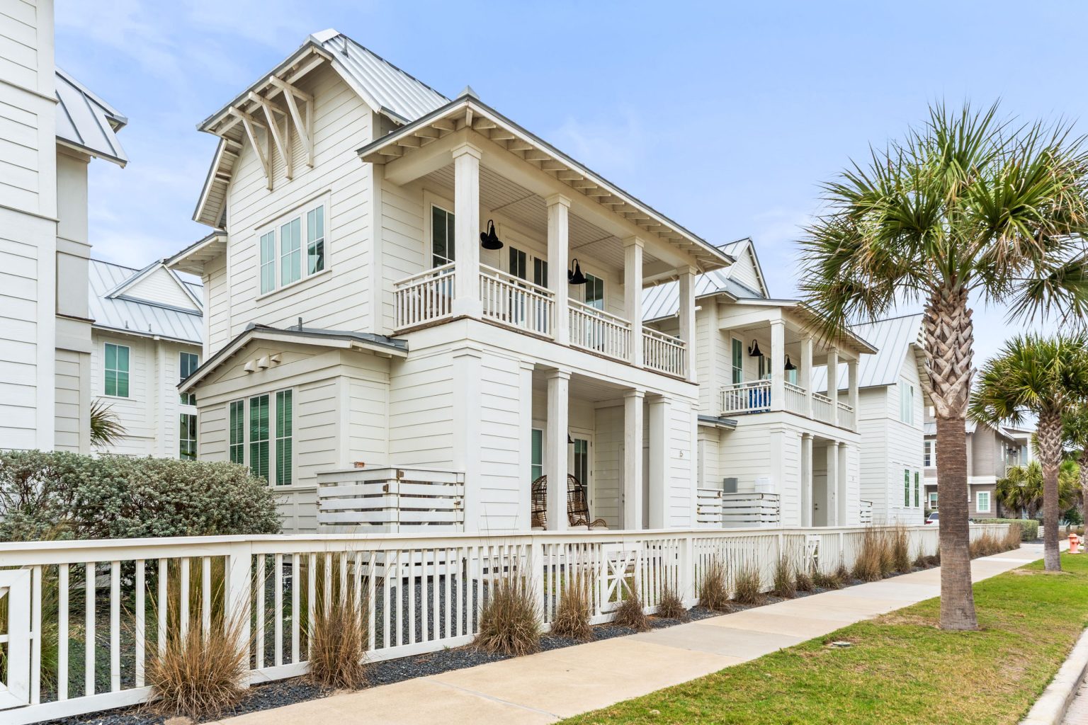 Exterior of the casita building at 214 Sunset Avenue with porches and palms