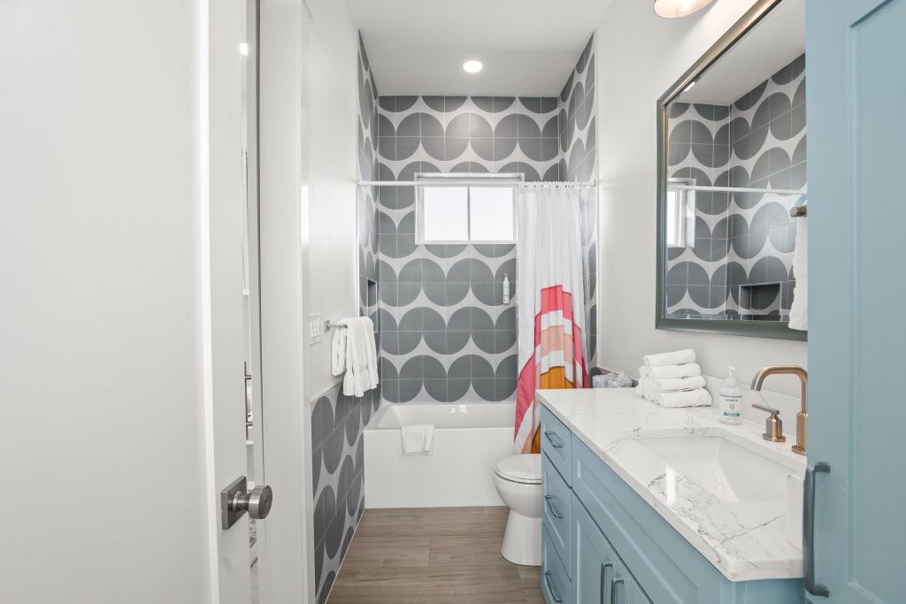 Bathroom with an aqua vanity and patterned tile tub-shower at 724 Sunset Avenue