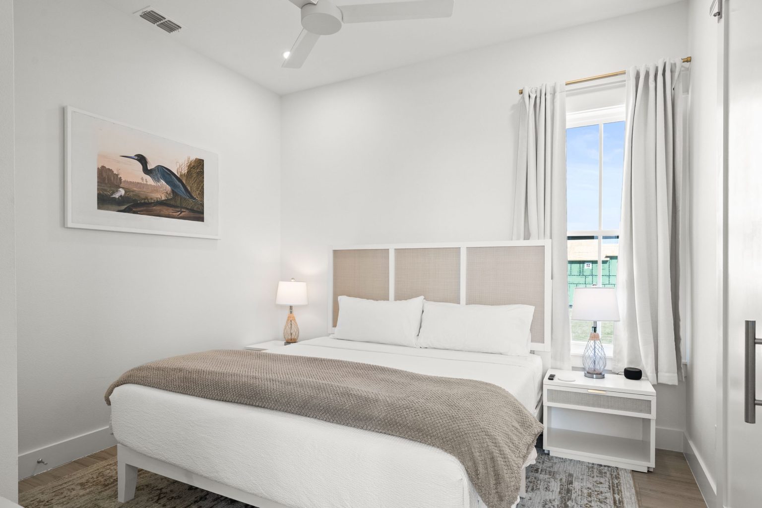 Bedroom with an upholstered bed and heron art at 724 Sunset Avenue