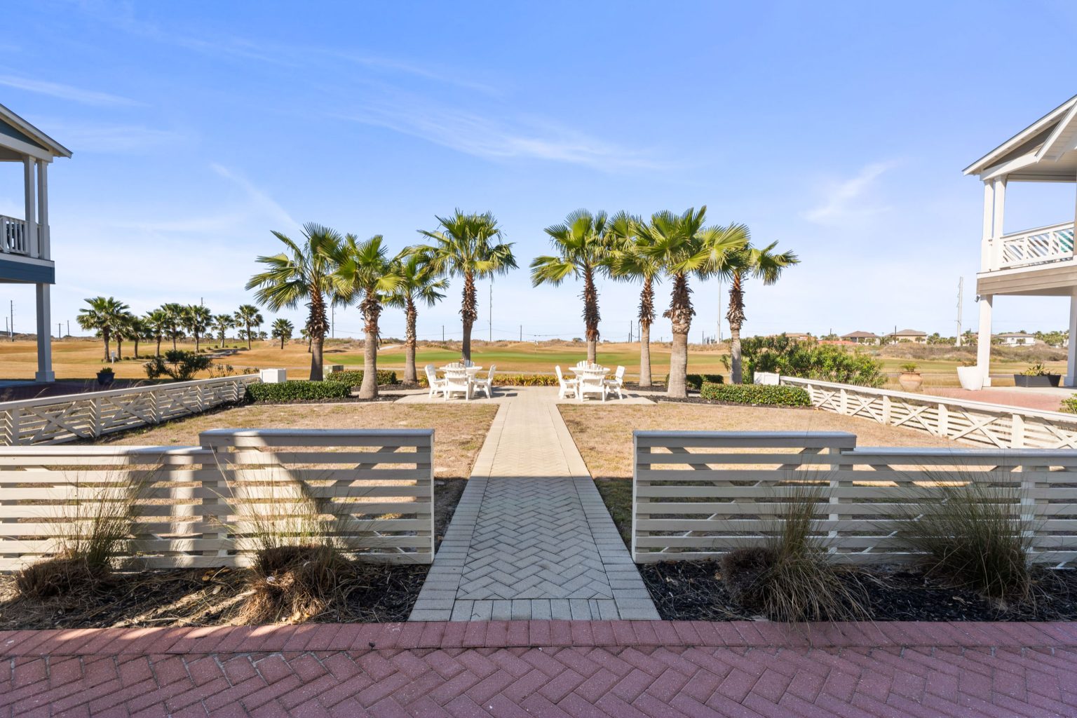 Walkway from 200 Sunset Avenue to a palm-lined common green