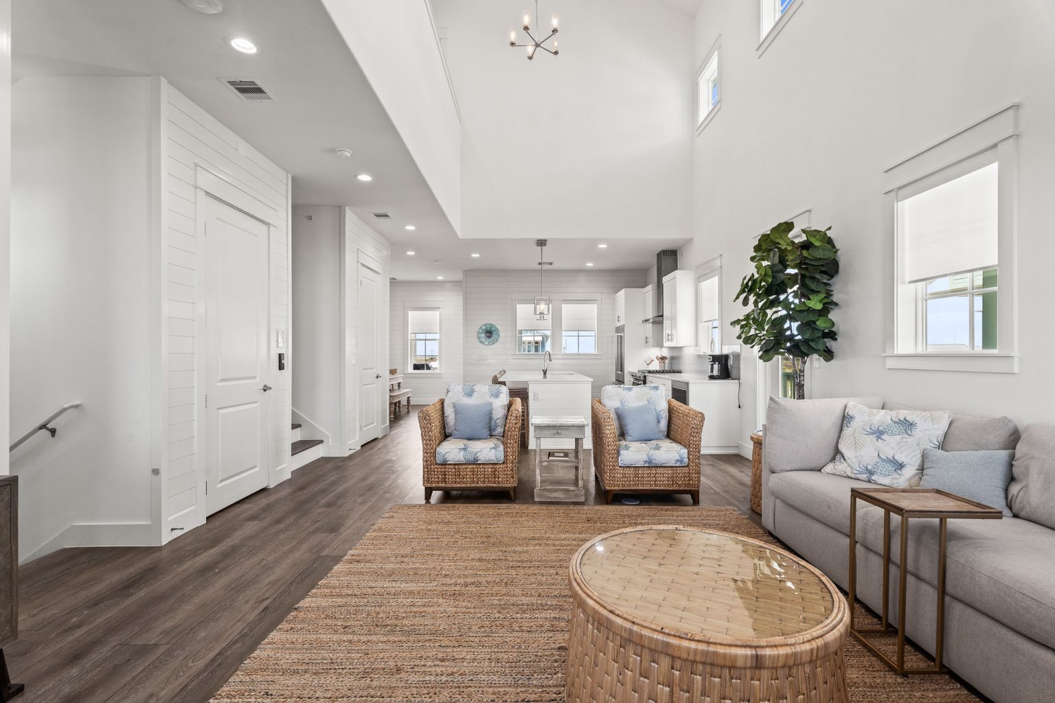 Open living area with rattan chairs and a gray sofa at 250 Sunrise Avenue