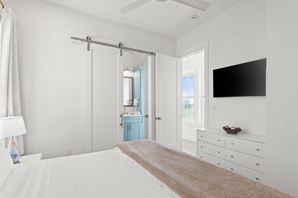 Bedroom with a sliding barn door and wall-mounted TV at 724 Sunset Avenue
