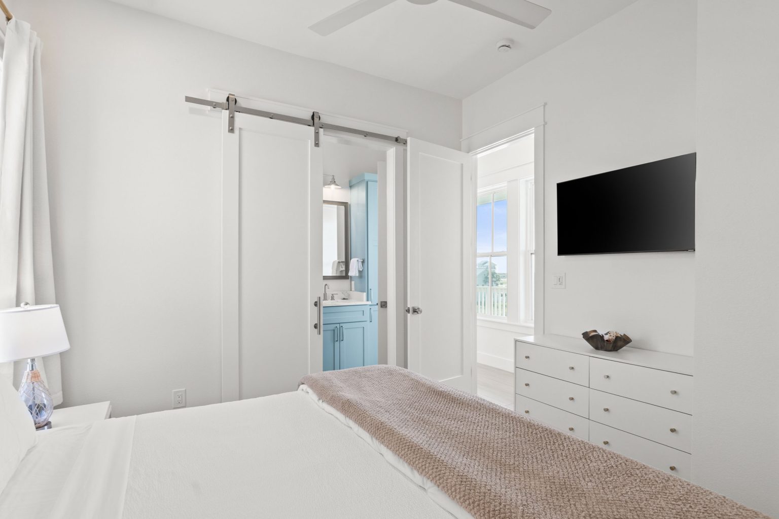 Bedroom with a sliding barn door and wall-mounted TV at 724 Sunset Avenue