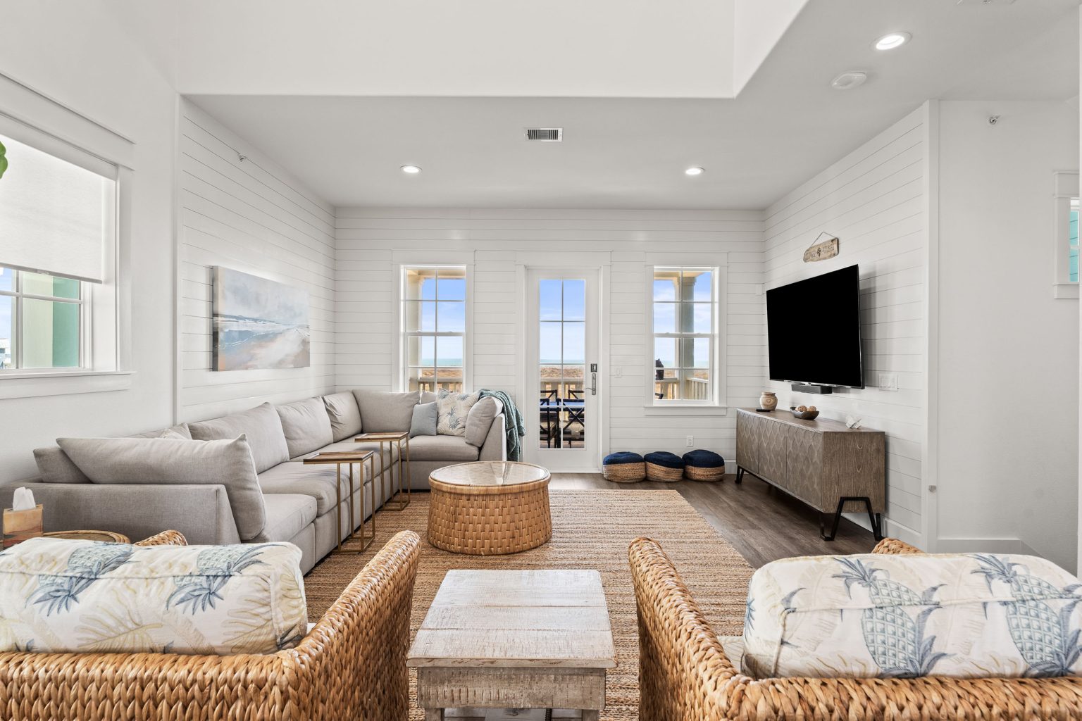 Living room with a large sectional and wicker chairs at 250 Sunrise Avenue