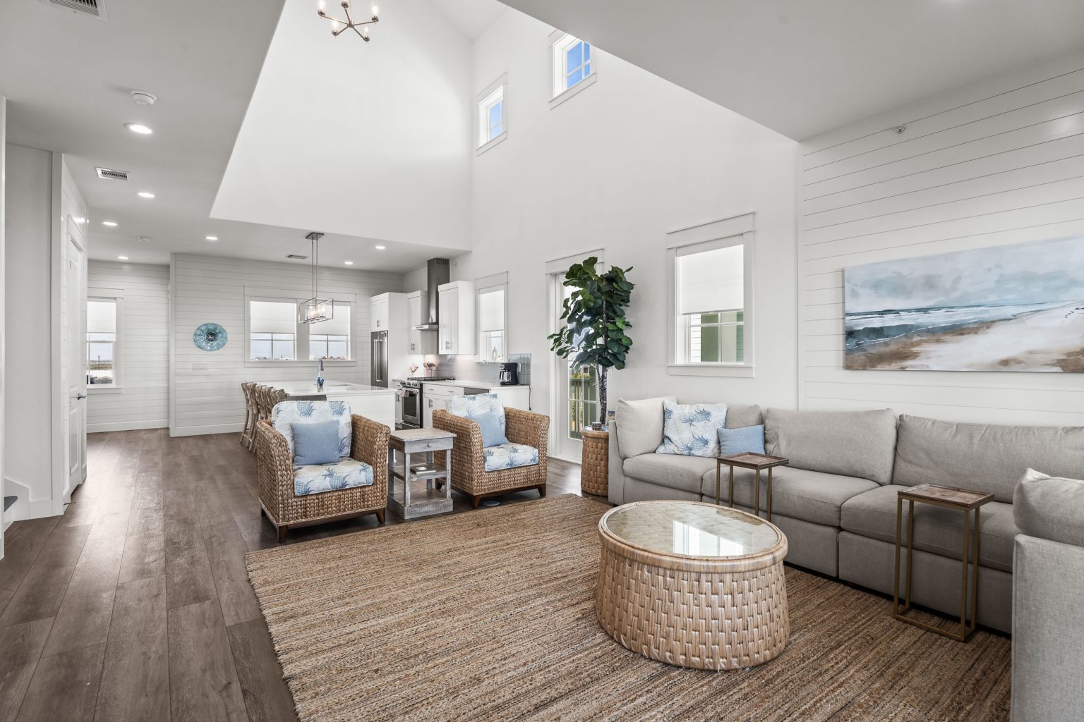 Living area with a beach painting and round rattan table at 250 Sunrise Avenue