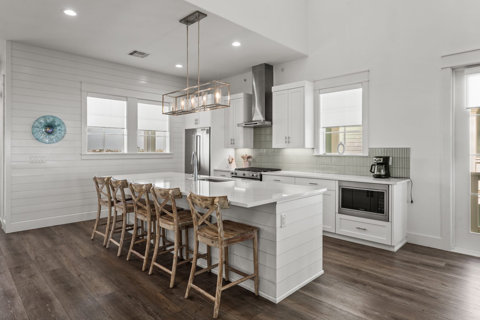 Kitchen with a long white island and barstools at 250 Sunrise Avenue