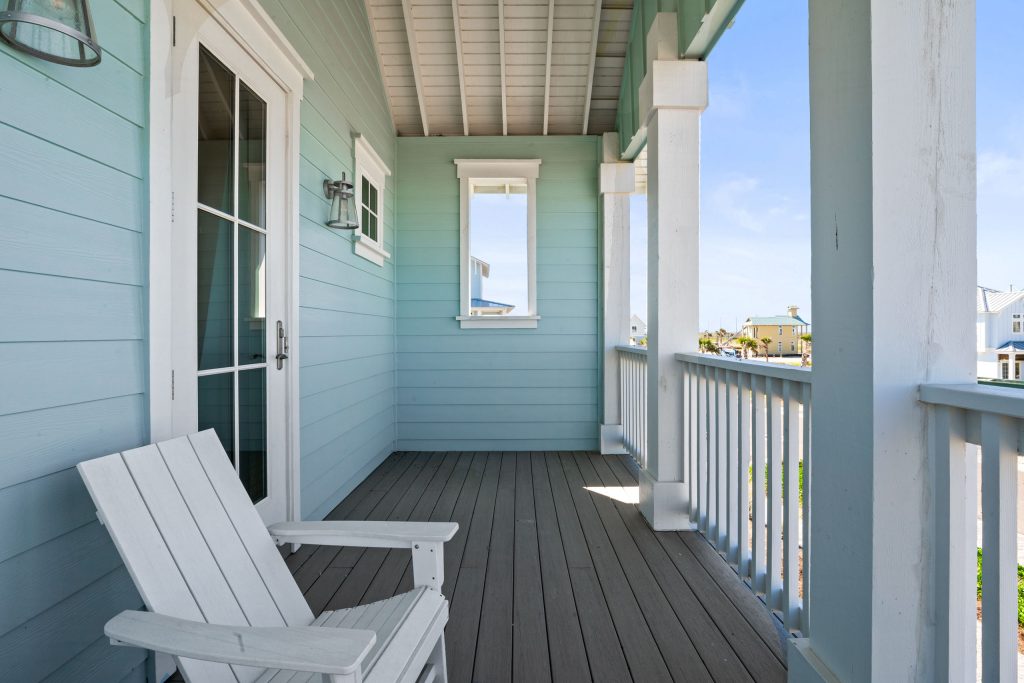 Covered upper porch with Adirondack chair at 724 Sunset Avenue